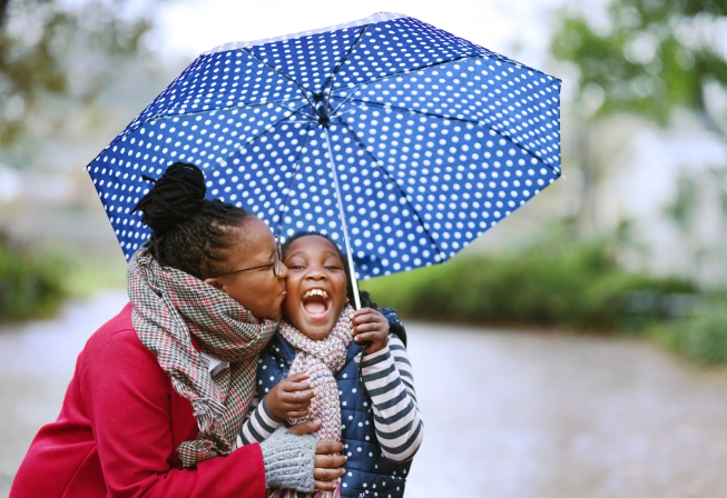 Mom and daughter with an umbrella in the rain.